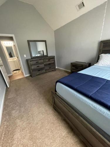 a bedroom with a bed and a dresser and a mirror at CLOSE TO ATLANTA & SIX FLAGS in Villa Rica