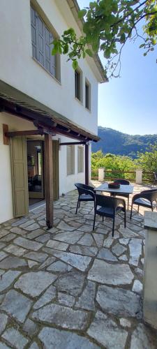 a patio with a table and chairs and a building at Deluxe house in Tsangarada in Tsagarada