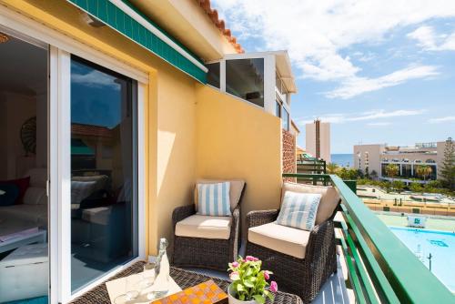 - un balcon avec deux chaises et une piscine dans l'établissement CristiSmart Home Hi-End Services Media Streaming, à Los Cristianos