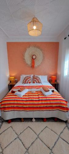 a bedroom with a large bed with an orange wall at CASA ZOUINA in Agadir