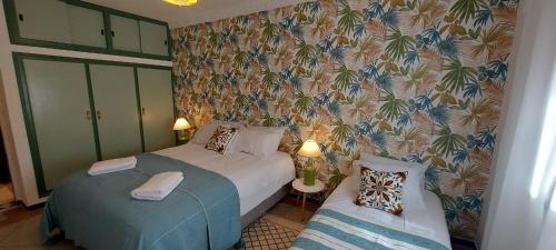a bedroom with two beds and a wall mural at CASA ZOUINA in Agadir