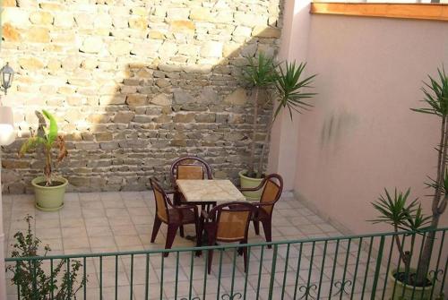 a table and chairs on a balcony with a brick wall at L’Ostalou in Issoire