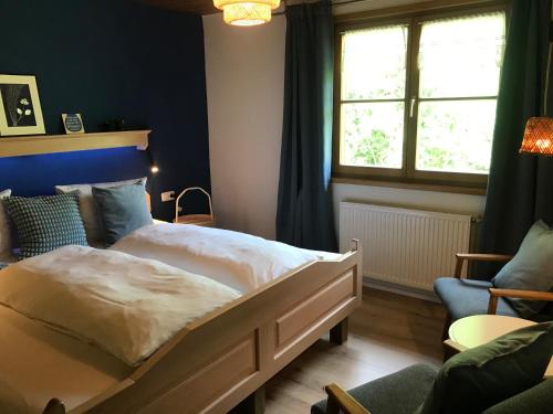 a bedroom with a large bed and a window at Ferienwohnung Morgentau am Rande der Wildnis in Sibratsgfäll