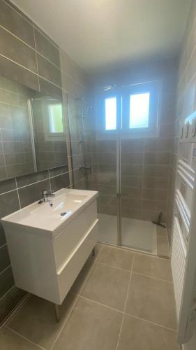 une salle de bain avec un lavabo blanc et une douche dans l'établissement BEAUSOLEIL , appartement neuf, climatisé , Jardin clos , 2 chambres, parking privé, calme, 900 m du centre de nyons, à Nyons