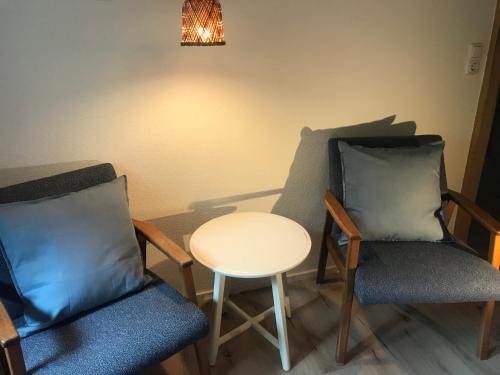 a room with two chairs and a table and a chandelier at Ferienwohnung Morgentau am Rande der Wildnis in Sibratsgfäll