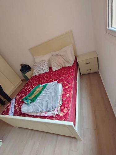 een kleine slaapkamer met een bed met een rode deken bij Appart marackech in Marrakesh