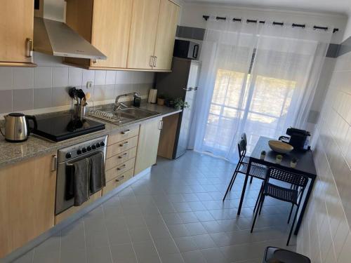 a kitchen with a sink and a stove and a table at House of Grace Charm Apartment in Santana