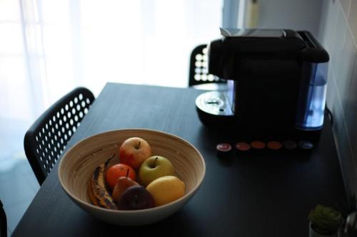 a bowl of fruit on a table next to a coffee maker at House of Grace Charm Apartment in Santana