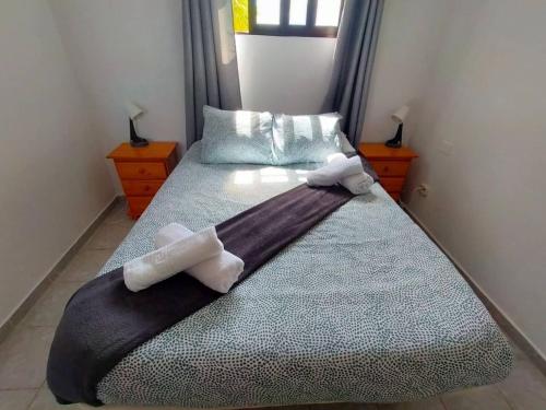 a bedroom with a bed with two towels on it at Impeccable 2-Bed House in Guia de Isora in Guía de Isora