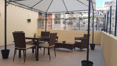una mesa y sillas con una sombrilla en el balcón en Residenza La Terrazza locazione turistica, en Bari