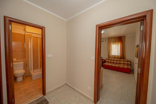 d'une salle de bains avec toilettes et d'une chambre avec canapé. dans l'établissement Beach apartments, à Petrovac na Moru