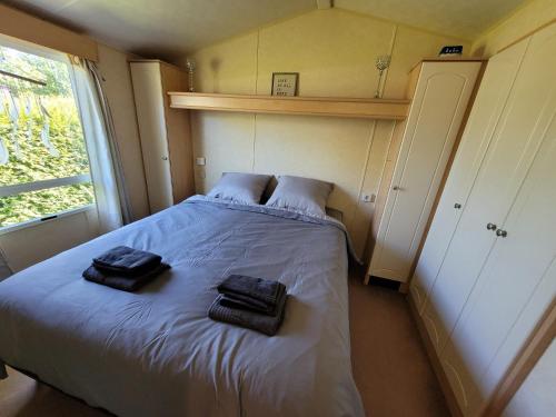 een slaapkamer met een bed met twee handdoeken erop bij Chalet E009 with a large garden in Renswoude