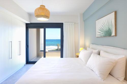 a bedroom with a bed with a view of the ocean at Dione Seaside Apartments in Hersonissos