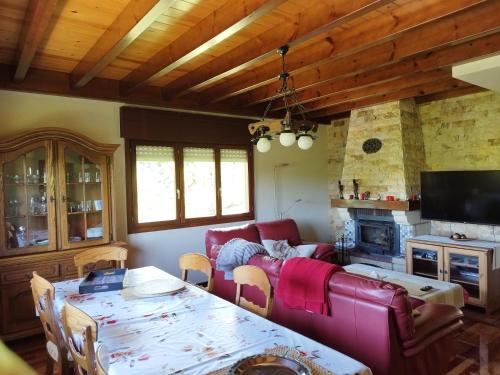 a living room with a red couch and a table at PISCINA CLIMATIZADA - todo el año- Playa de la Ñora-chimenea- barbacoa in Quintueles