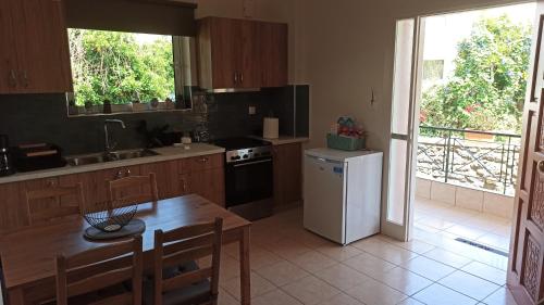 a kitchen with a table and a white refrigerator at limonchello 2 in Kalamata
