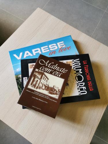two books sitting on top of a table at Curt da Beta - Casa vacanze con giardino, in Corte del XVIII secolo in Malnate