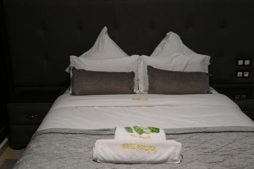 a white bed with two towels on top of it at Hôtel Mansour in Dakhla