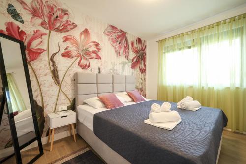 1 dormitorio con 1 cama con toallas en Apartmani Mato 1, en Zadar
