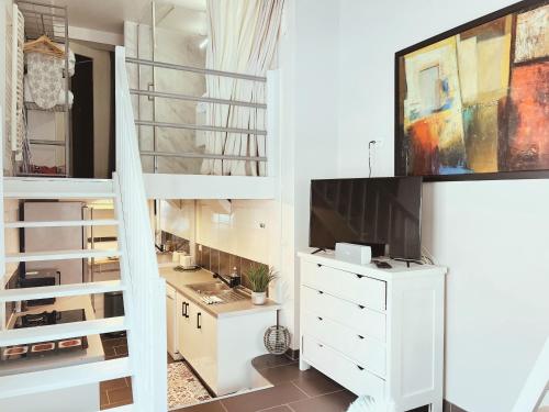 Cette chambre dispose d'une commode blanche et d'une télévision. dans l'établissement Loft Mandallaz - Au coeur de la ville, à Annecy