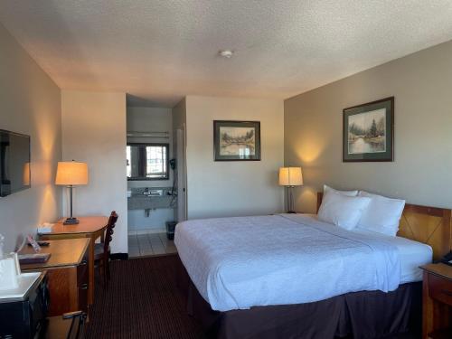 a hotel room with a large bed and a desk at Skyway Inn - Seatac in SeaTac