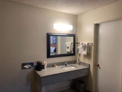 a bathroom with a sink and a mirror at Skyway Inn - Seatac in SeaTac
