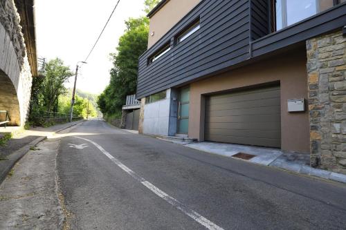 Yvoir的住宿－Aux Berges du Bocq，一条空的街道,旁边是一座带车库的建筑