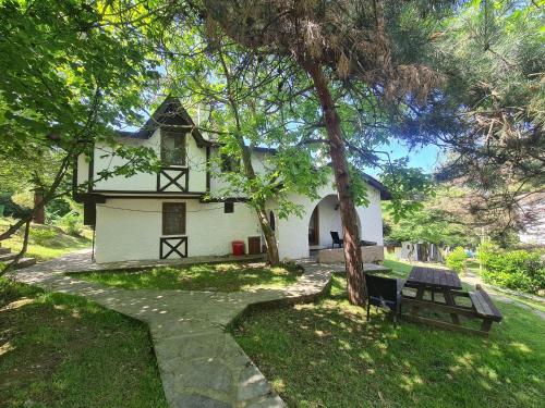 una casa blanca con un banco delante en Polonezköy Country Club & Accommodation in the Wildlife Park! en Beykoz