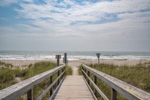 a wooden boardwalk leading to a beach with the ocean at Second Row - Ocean View - Near Kure Beach Pier in Kure Beach