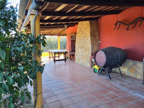 een patio van een huis met een tafel en een vat bij La Buganvilla, descanso entre olivares in Hornachuelos