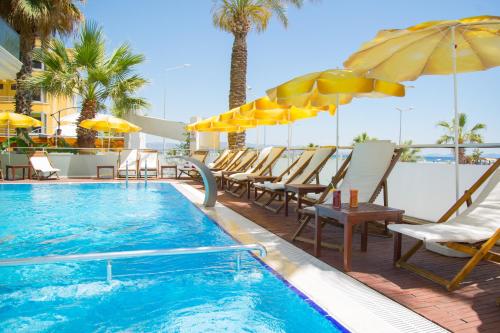 een zwembad met stoelen en parasols op een resort bij Acem Hotel in Ayvalık