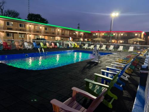 a swimming pool with lounge chairs in front of a building at Wolf Inn Hotel in Sandusky