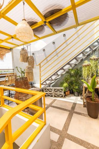 a patio with a yellow railing and potted plants at Rain Airport Bed and Breakfast in Manila