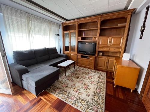 ein Wohnzimmer mit einem Sofa und einem TV in der Unterkunft Gran Apartamento con vistas a la Catedral de Burgos ATUAIRE in Burgos