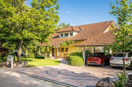 ein Haus mit zwei Autos in der Einfahrt in der Unterkunft Haus Ahorn in Bad Dürrheim