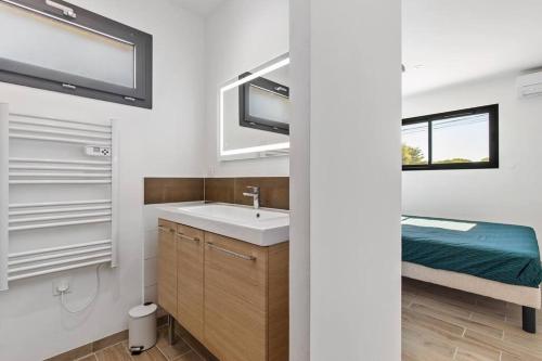 une salle de bain avec un lavabo et un miroir dans l'établissement Villa SUN - 600m plage - clim - 6 pers - Cap d'Agde, au Cap d'Agde