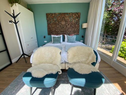 阿納姆的住宿－Appartement Osso Arnhem，一间卧室配有一张蓝色墙壁的床和两把椅子
