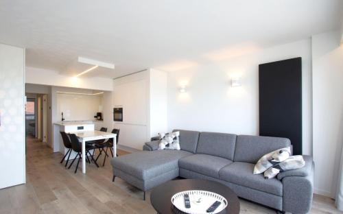 ein Wohnzimmer mit einem Sofa und einem Tisch in der Unterkunft Riva Bella 1.01 in Nieuwpoort