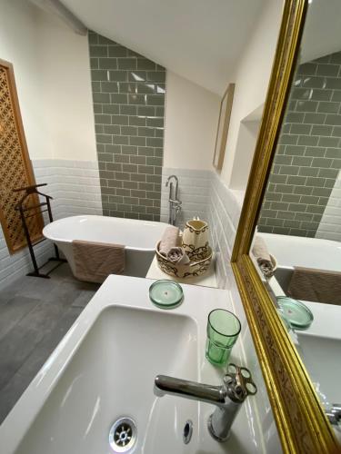 La salle de bains est pourvue d'un lavabo blanc et d'une baignoire. dans l'établissement Dar Aminya - Chambres d'hôtes, à Marmande