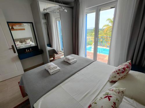 a bedroom with a bed with a view of a pool at Iridia Resort Villas in Foiníki