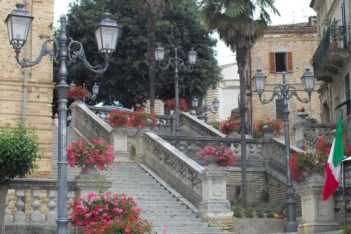 um conjunto de escadas com flores e luzes e luzes de rua em Ferruccio's House em Colonnella