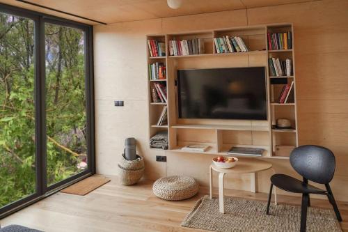 a living room with a television and a table and a chair at Riverfront Cabins in the garden in Poznań