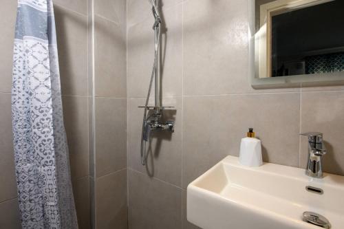 uma casa de banho com um chuveiro, um lavatório e um chuveiro em Suzana's Maisonette em Prinos