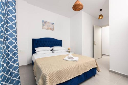 una camera con letto e testiera blu di Suzana's Maisonette a Prinos