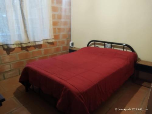 1 dormitorio con 1 cama con manta roja en Alma Mía en Lobos