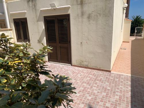 a house with a brown door and a brick floor at Mari-Mare Home in Rodi Garganico