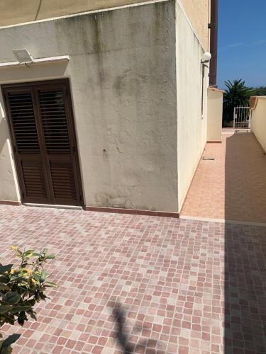 a building with a door and a brick walkway at Mari-Mare Home in Rodi Garganico