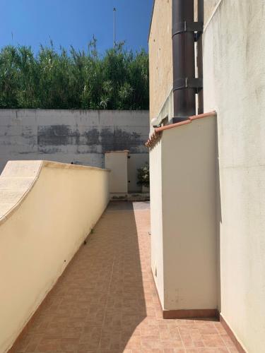 an empty hallway with a white wall and a brick sidewalk at Mari-Mare Home in Rodi Garganico