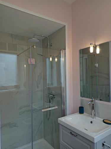 a bathroom with a glass shower and a sink at La petite chouette in Rochesson