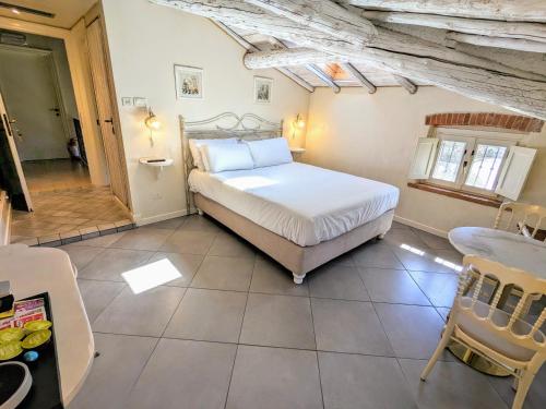 - une chambre avec un grand lit dans une pièce avec une table dans l'établissement Casal del pigno, à Peschiera del Garda