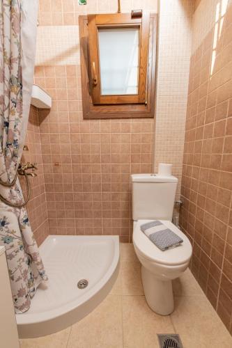 a bathroom with a toilet and a tub and a mirror at Villa Filyra in Kato Gatzea
